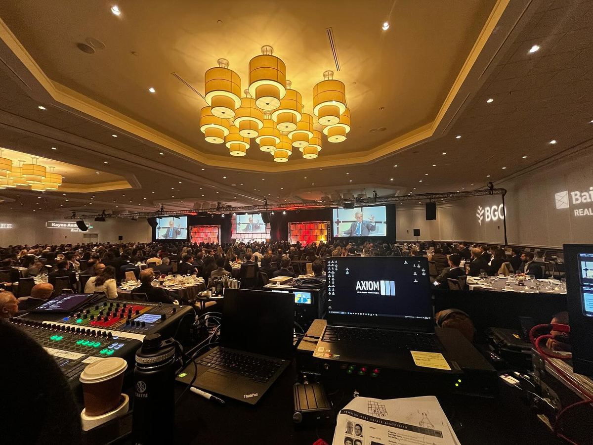 Hotel ballroom set for a general session with screens